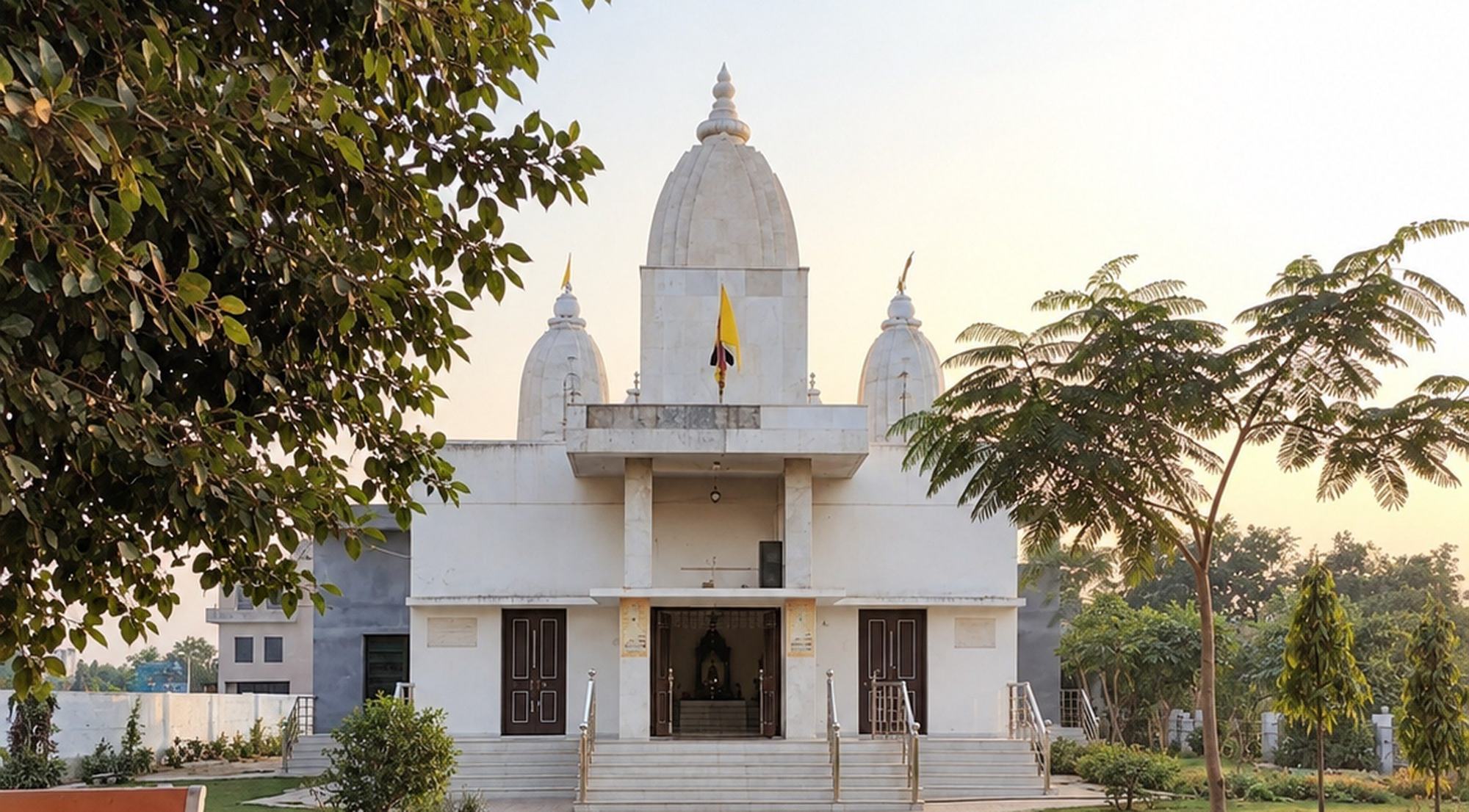 हांसी गीता भवन का मंदिर सामने से, गर्भगृह के खुले द्वारों के ऊपर उठता श्वेत शिखर